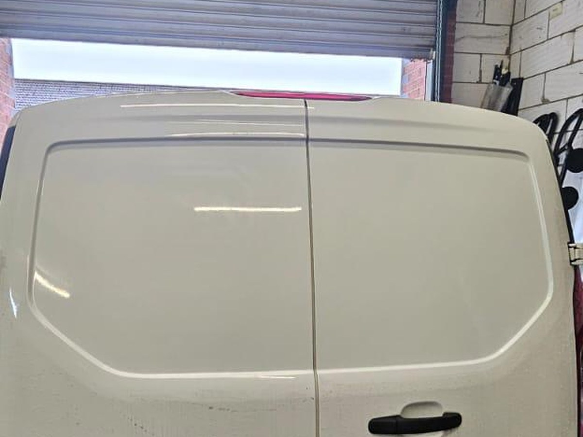 Bare rear doors of a Ford Transit Connect before window conversion